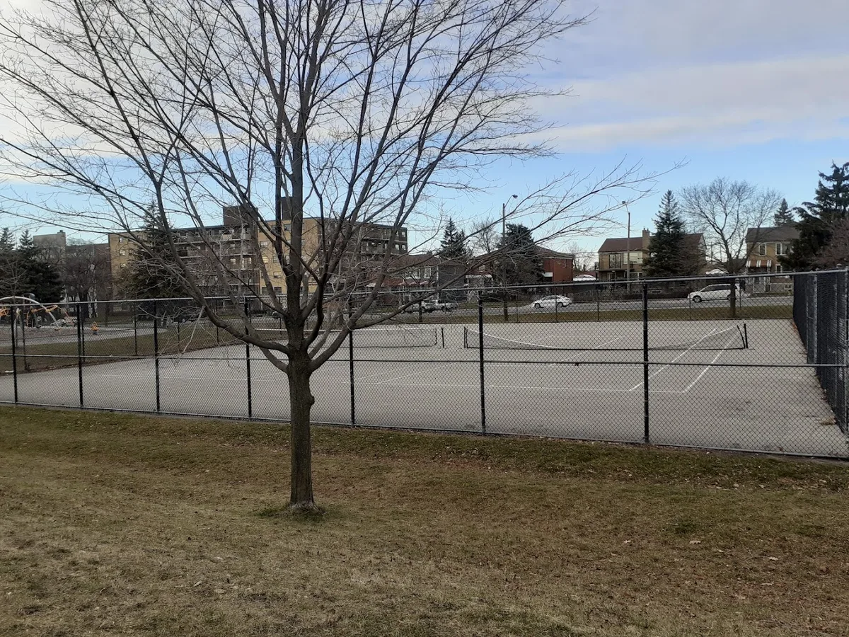 Empty fenced outdoor court with tennis net at Amesbury Park, Toronto