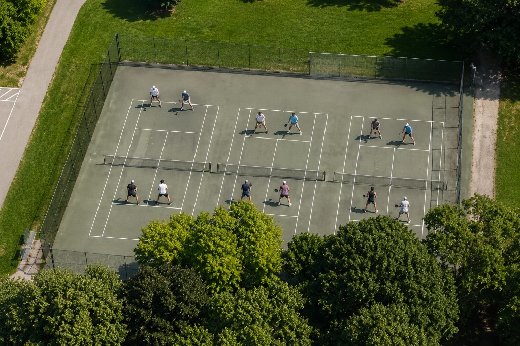 Overhead view of fenced pickleball courts at High Park in a leafy park setting